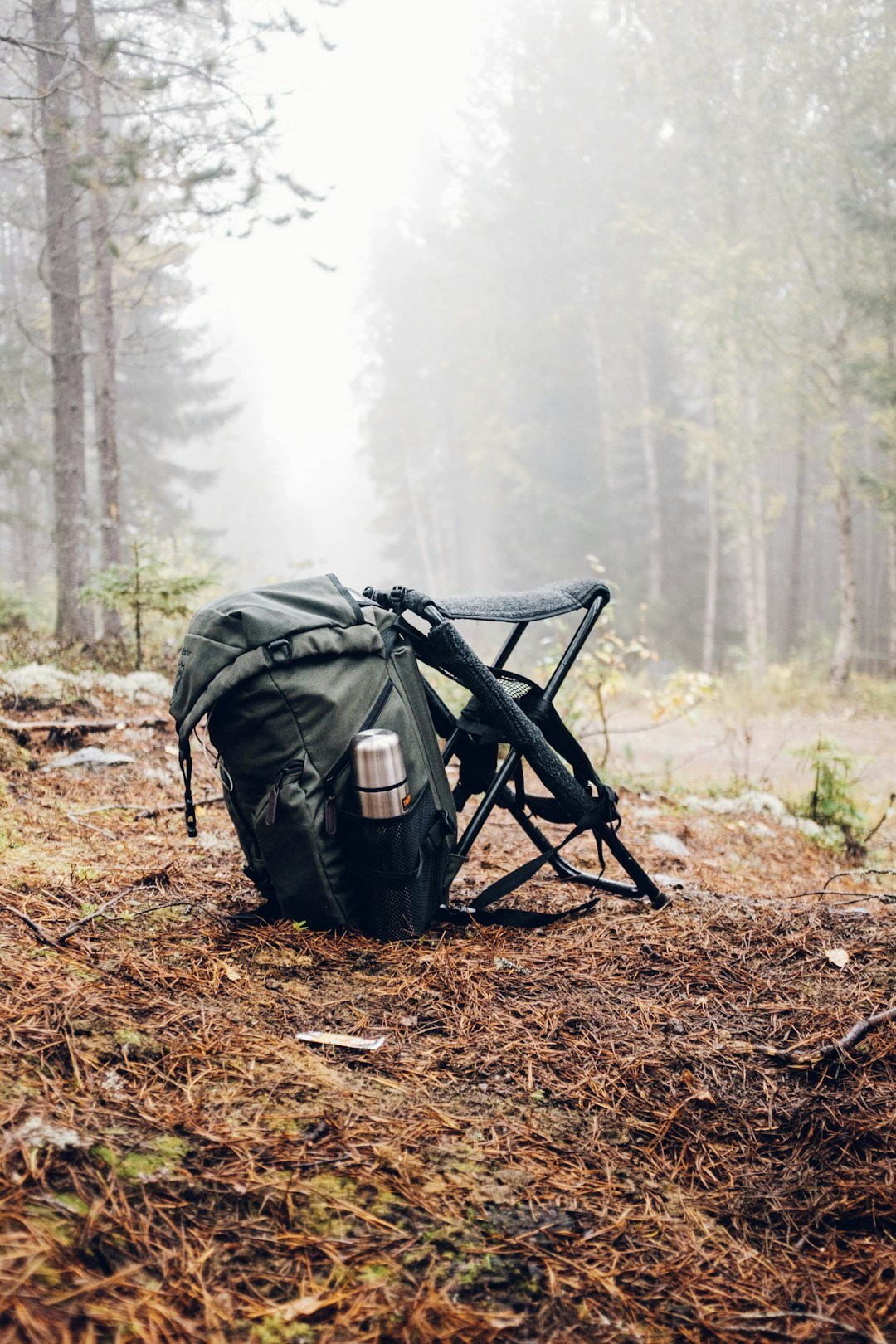black-and-gray-backpack-with-camping-chair-on-forest-m-xwt-xf6ks