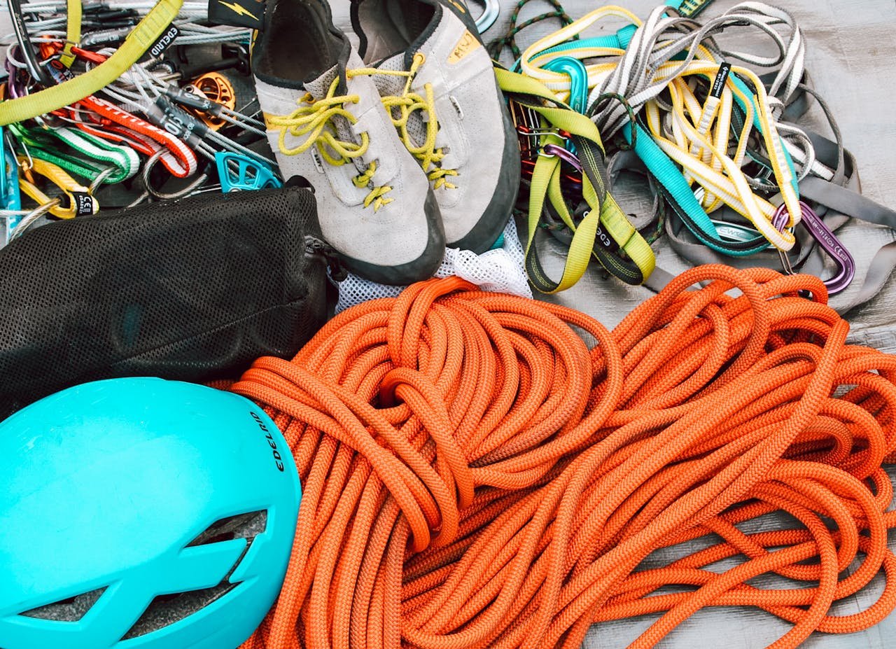 Close-up of mountain climbing gear including ropes, helmet, and harnesses for safety.
